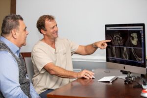 dr gary ashton working with a dental implant patient in leesburg, Va.